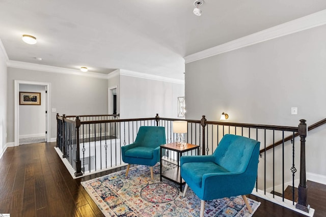 living area featuring hardwood / wood-style floors, baseboards, an upstairs landing, and ornamental molding