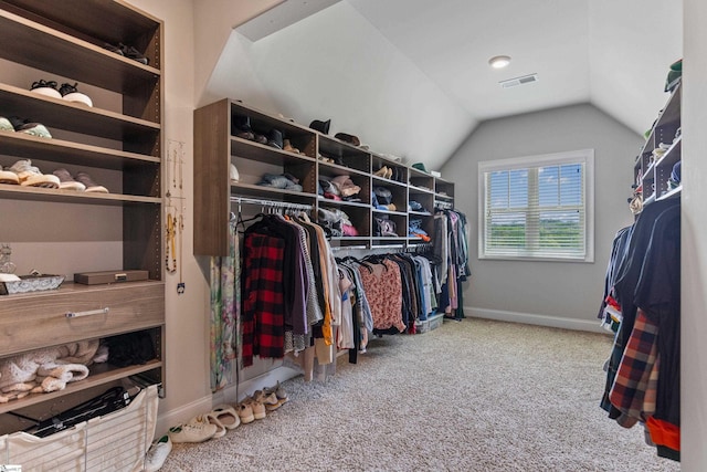 walk in closet with vaulted ceiling, visible vents, and carpet flooring