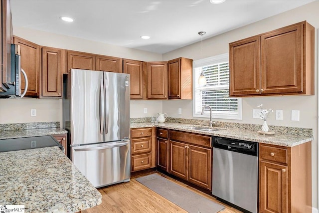 kitchen featuring brown cabinets, stainless steel appliances, and a sink