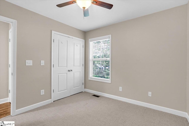 unfurnished bedroom with baseboards, visible vents, and light colored carpet