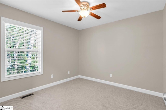 unfurnished room with visible vents, ceiling fan, baseboards, and light colored carpet