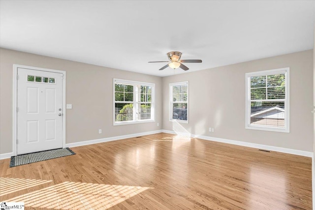 interior space featuring plenty of natural light, baseboards, a ceiling fan, and light wood-type flooring
