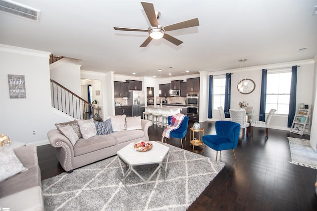 living area with ceiling fan, ornamental molding, stairs, and visible vents