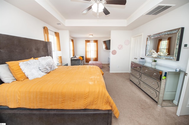 carpeted bedroom with baseboards, crown molding, visible vents, and a raised ceiling