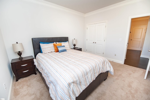 carpeted bedroom with baseboards, a closet, and crown molding