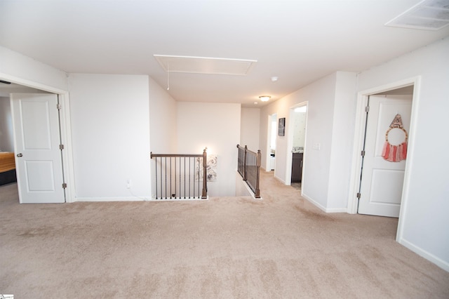 spare room with attic access, carpet, visible vents, and baseboards