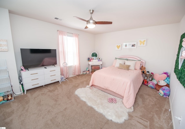 bedroom featuring a ceiling fan, visible vents, and light colored carpet