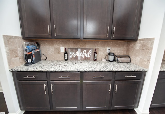 bar featuring dark wood finished floors, baseboards, and tasteful backsplash