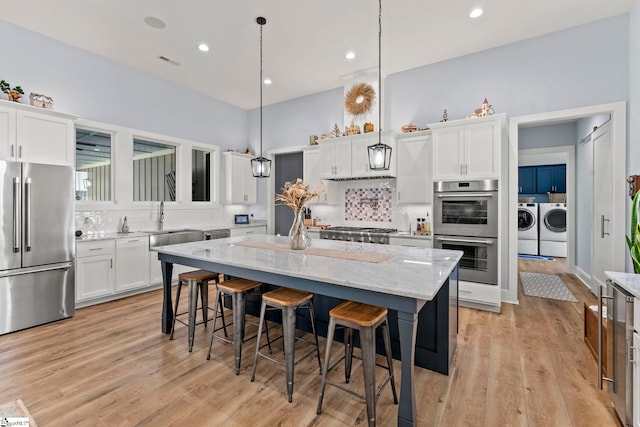 1359 Martin Creek Rd, Seneca, SC 29678 - kitchen featuring washer and dryer, backsplash, appliances with stainless steel finishes, and white cabinets