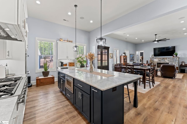 1359 Martin Creek Rd, Seneca, SC 29678 - kitchen with stainless steel microwave, white cabinetry, a center island, and light wood-type flooring