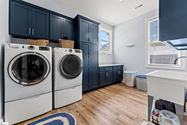 1359 Martin Creek Rd, Seneca, SC 29678 - washroom featuring a sink, cabinet space, light wood finished floors, visible vents, and independent washer and dryer