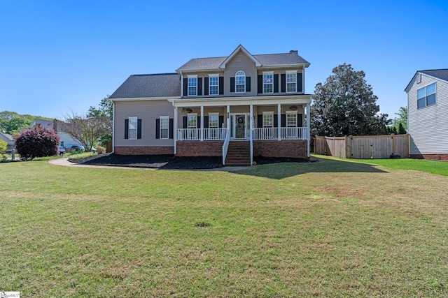 colonial-style house featuring fence, a porch, and a front yard