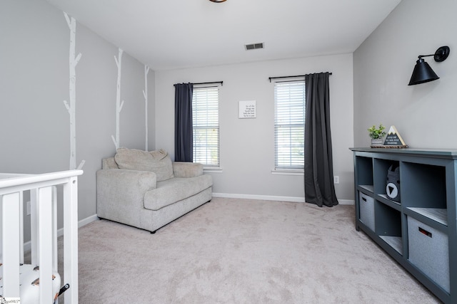 living area featuring baseboards, visible vents, and carpet