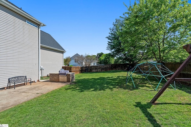 view of yard featuring an outdoor kitchen, a fenced backyard, and a patio