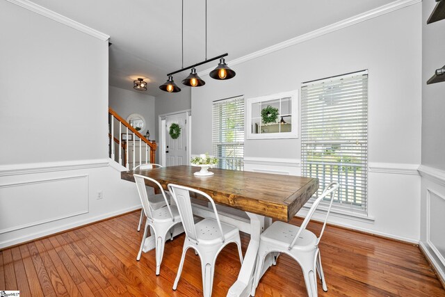 dining space featuring stairway, crown molding, and wood finished floors