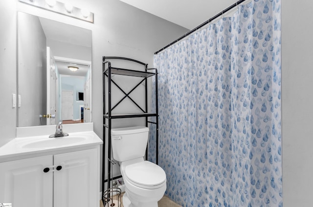 bathroom with toilet, vanity, and curtained shower