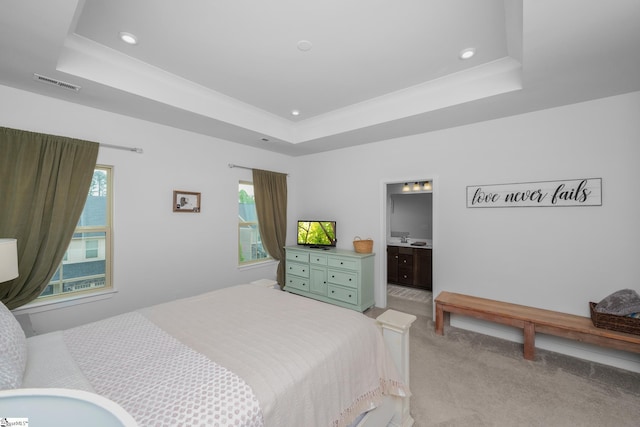bedroom with light colored carpet, visible vents, and a raised ceiling