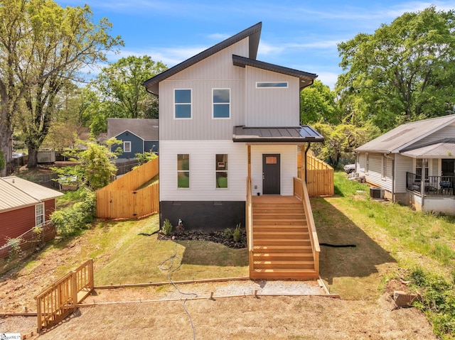 view of front of home with central AC unit, fence, and metal roof