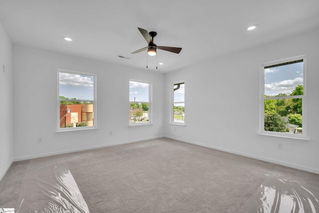 empty room with light colored carpet, ceiling fan, visible vents, and recessed lighting