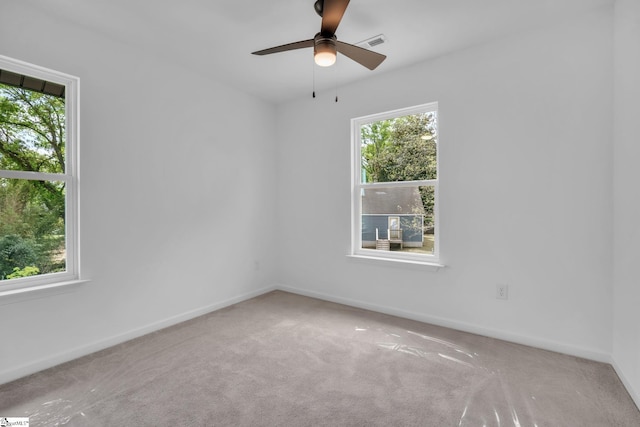 carpeted empty room featuring ceiling fan, baseboards, and visible vents