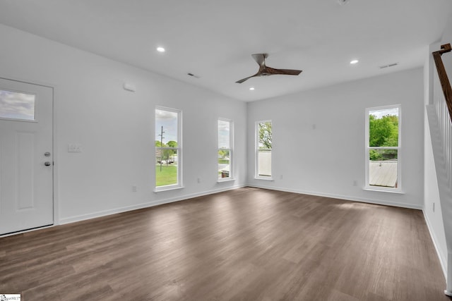 unfurnished living room with a wealth of natural light, a ceiling fan, and wood finished floors
