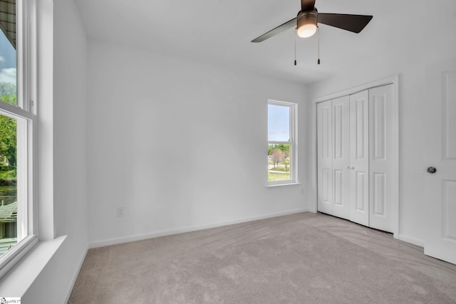 unfurnished bedroom with baseboards, a ceiling fan, carpet flooring, and a closet