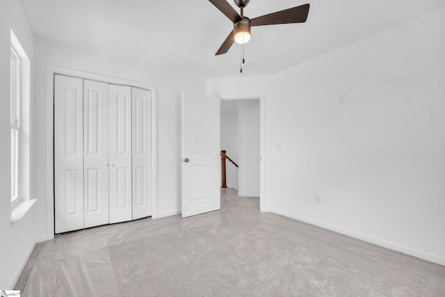 unfurnished bedroom featuring ceiling fan, baseboards, a closet, and carpet