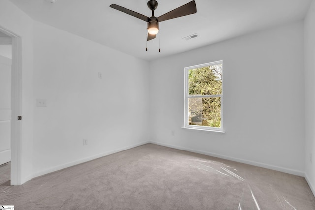 unfurnished room with visible vents, a ceiling fan, baseboards, and carpet