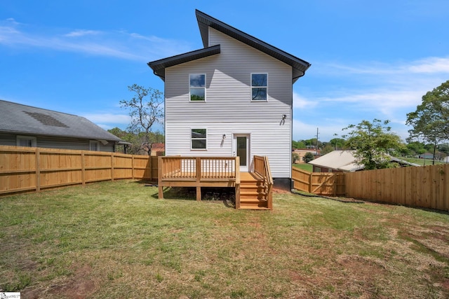 back of house with a fenced backyard, a wooden deck, and a yard
