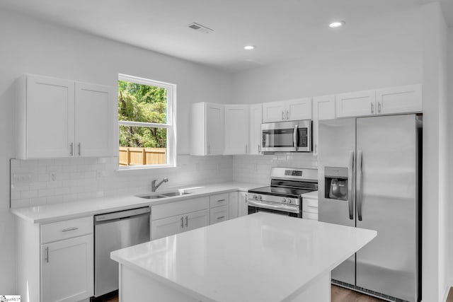kitchen featuring white cabinets, stainless steel appliances, visible vents, and a sink