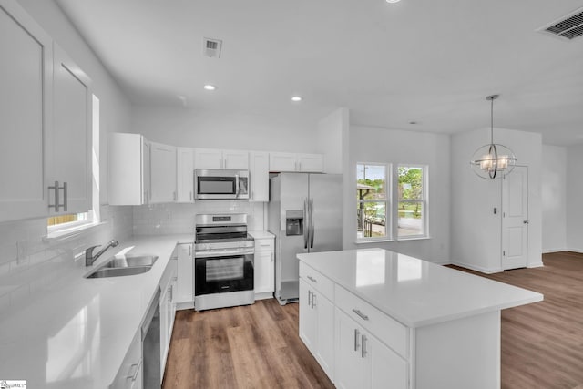 kitchen featuring decorative backsplash, appliances with stainless steel finishes, a sink, and visible vents