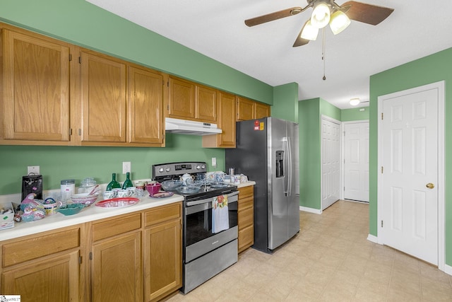 kitchen with stainless steel appliances, a ceiling fan, light floors, light countertops, and under cabinet range hood