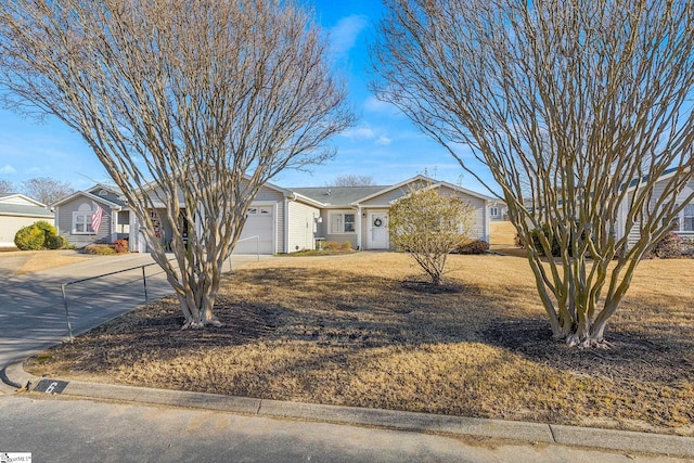 view of front of house with concrete driveway, a front lawn, and a garage