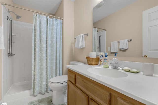 bathroom with tile patterned flooring, a tile shower, toilet, and vanity