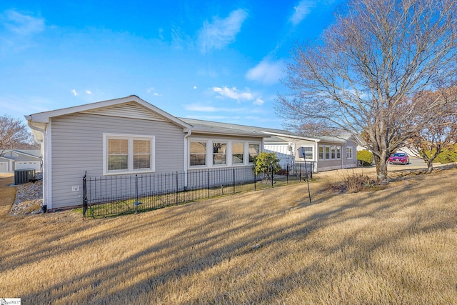ranch-style home featuring central AC, a front lawn, and fence