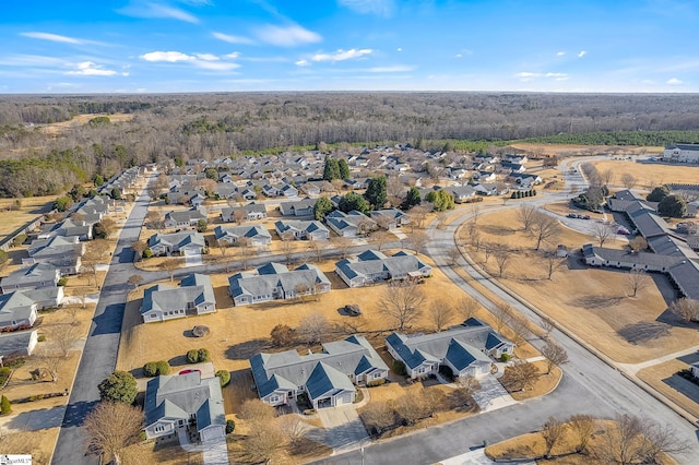 drone / aerial view featuring a view of trees and a residential view