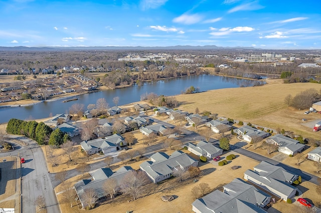 drone / aerial view featuring a water and mountain view and a residential view