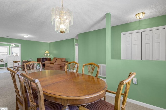 dining area with an inviting chandelier, visible vents, carpet, and a textured ceiling