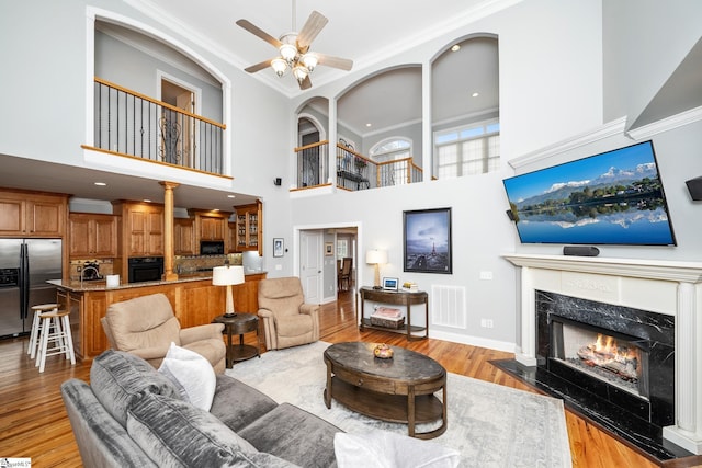 127 Warren Dr, Easley, SC 29640 - living area with light wood-type flooring, visible vents, a ceiling fan, a fireplace, and ornamental molding