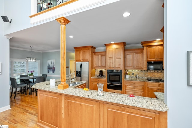127 Warren Dr, Easley, SC 29640 - kitchen featuring ornate columns, a warming drawer, light wood-type flooring, tasteful backsplash, and appliances with stainless steel finishes