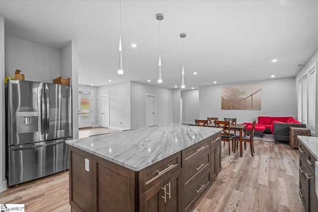 308 Pineridge Dr, Spartanburg, SC 29303 - kitchen featuring light stone counters, light wood-style floors, pendant lighting, stainless steel refrigerator with ice dispenser, and open floor plan