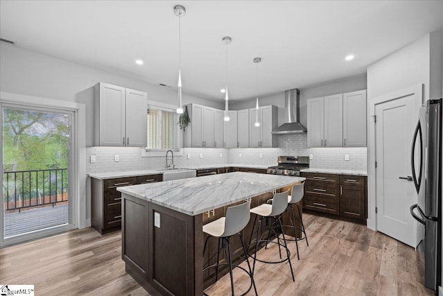 308 Pineridge Dr, Spartanburg, SC 29303 - kitchen with wall chimney range hood, a sink, freestanding refrigerator, a kitchen island, and gas stove