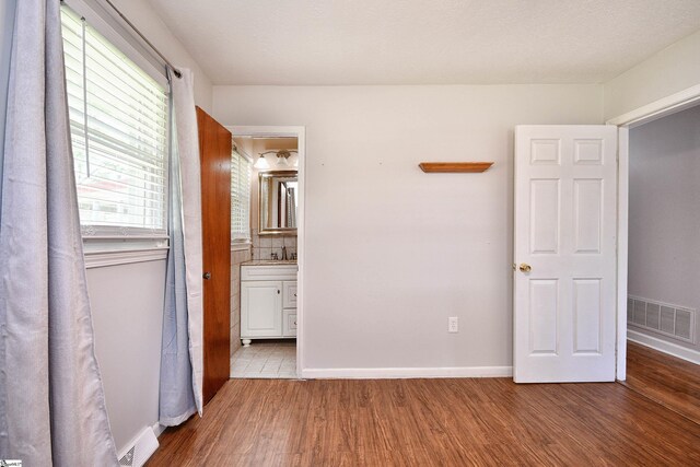 105 Ridgeland Cir, Easley, SC 29640 - unfurnished bedroom featuring visible vents, baseboards, ensuite bathroom, and wood finished floors