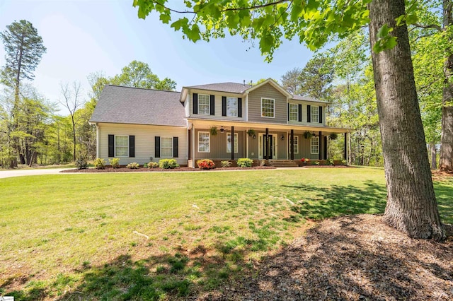 colonial house with a porch, a shingled roof, and a front yard