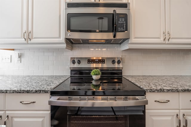 kitchen with light stone countertops, white cabinetry, appliances with stainless steel finishes, and tasteful backsplash
