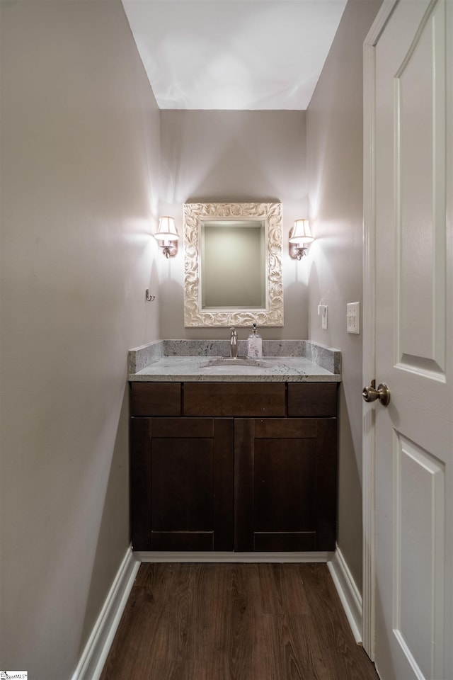 bathroom featuring baseboards, wood finished floors, and vanity