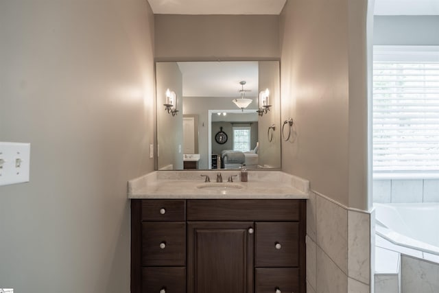 ensuite bathroom featuring a bath, ensuite bathroom, and vanity
