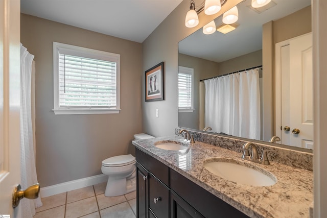 bathroom with baseboards, tile patterned flooring, a sink, and double vanity