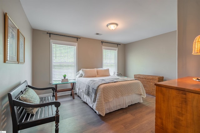 bedroom featuring wood finished floors and visible vents