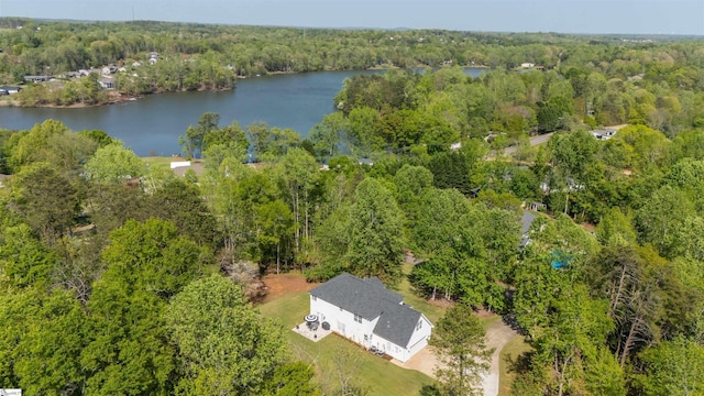 drone / aerial view featuring a wooded view and a water view